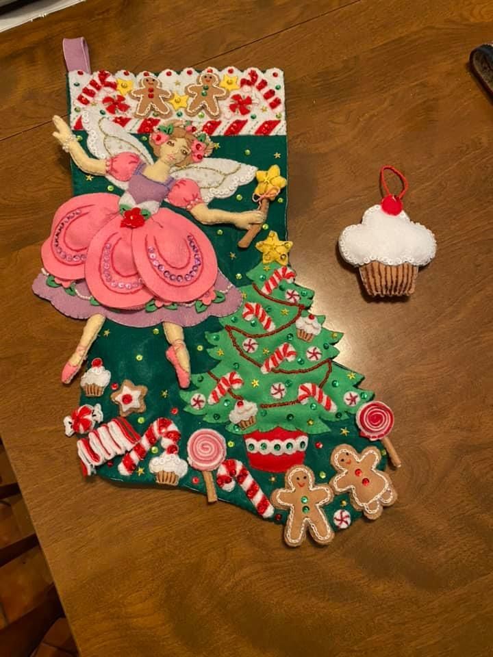 stocking with ballerina and a christmas tree. there's a cupcake ornament next to it