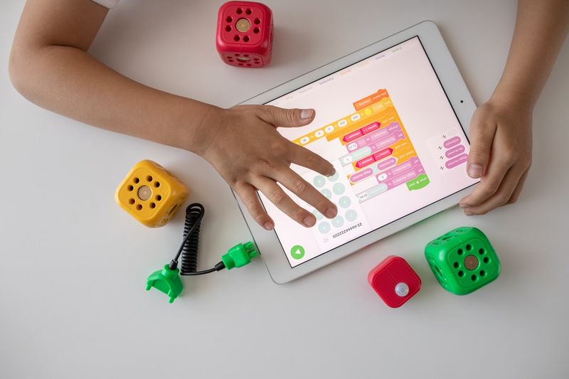 hands-on-tablet-play-interactive-game-with-toys-on-desk-robo-wunderkind-unsplash.jpg