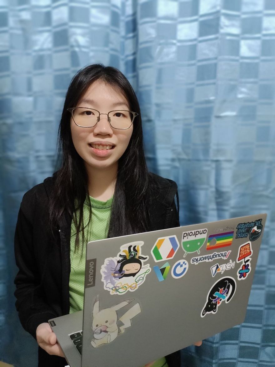 Image of Estee smiling holding their laptop