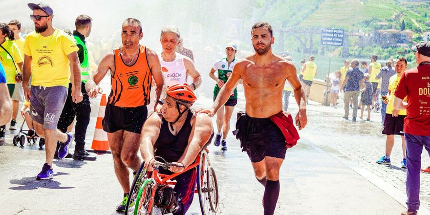 Photography showing different runners in a race. One of them is in a wheelchair