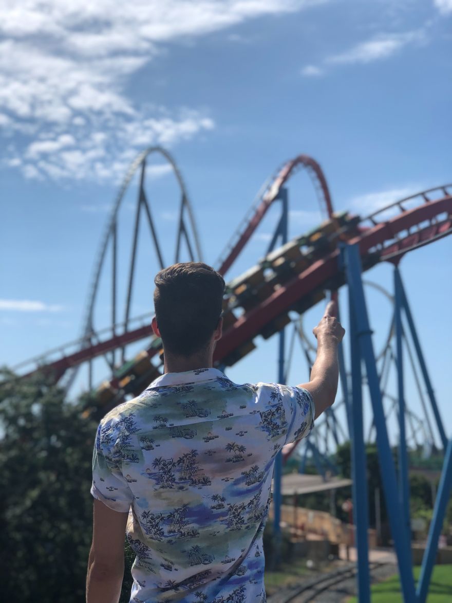 Man pointing at a rollercoaster in the distance