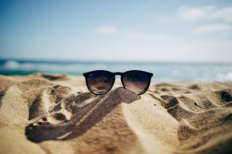 sunglasses-on-the-sand-at-a-beach.jfif